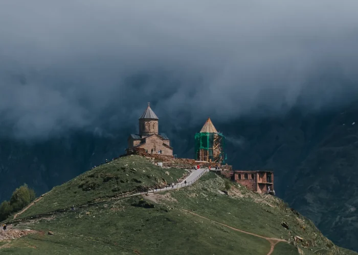 Gergeti Trinity Church above Stepantsminda under low clouds in Kazbegi, Georgia